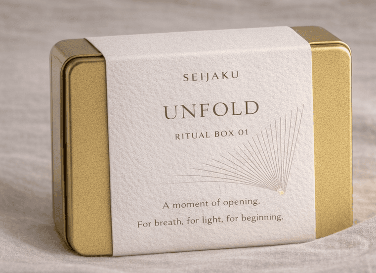 Seijaku Unfold Ritual Box 01 in gold tin with minimal white sleeve featuring fan illustration and soft neutral aesthetic